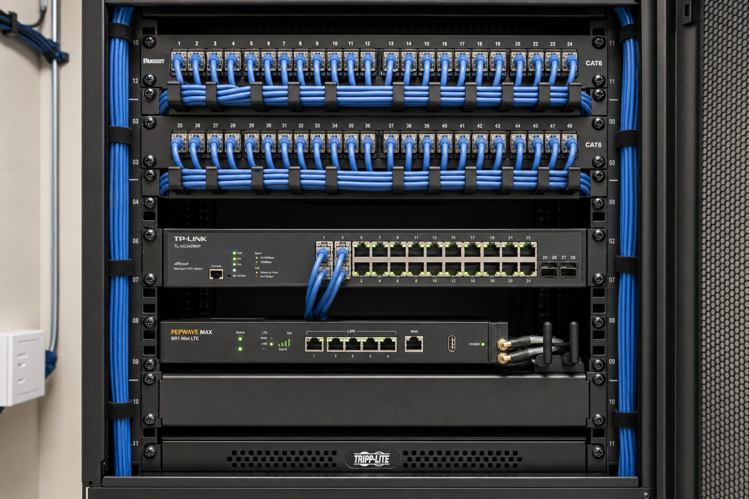 Network closet with patch panel, managed switch, and LTE failover router for business VoIP redundancy